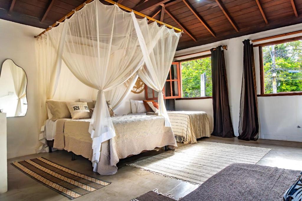 a bedroom with two beds with mosquito nets at La hospedaria in Trancoso
