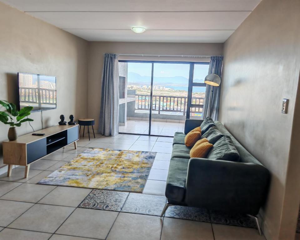 a living room with a couch and a large window at Vene's Place in Mossel Bay