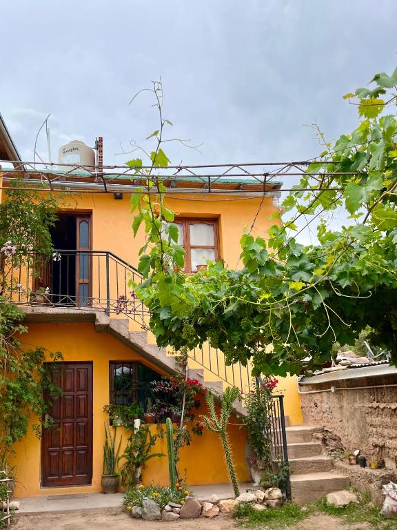 a yellow house with a staircase in front of it at Casa Mamani in Tilcara