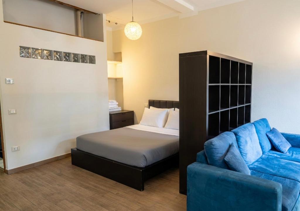 a bedroom with a bed and a blue couch at Suite Cerchio 2 - City Center in Ravenna