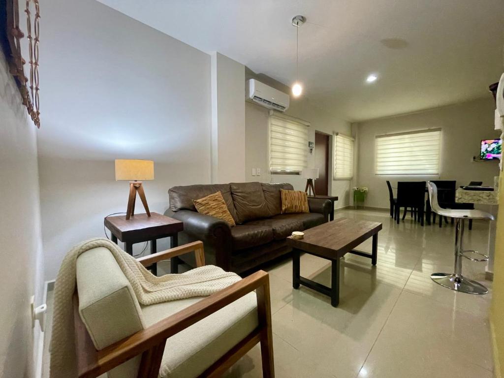 a living room with a couch and a table at Charming Condo in Gaviotas Walk to Beach cafes, restaurants within Golden Zone in Mazatlán