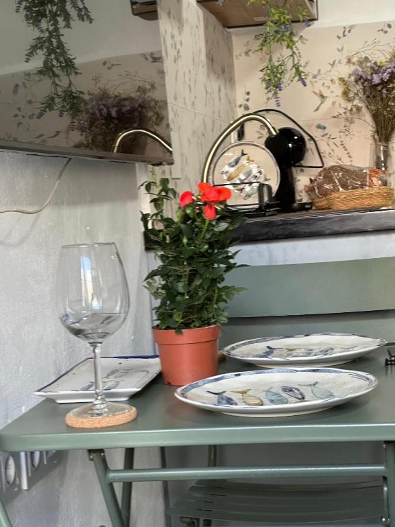 a table with plates and a glass and a plant at Buganvilla in Tarifa