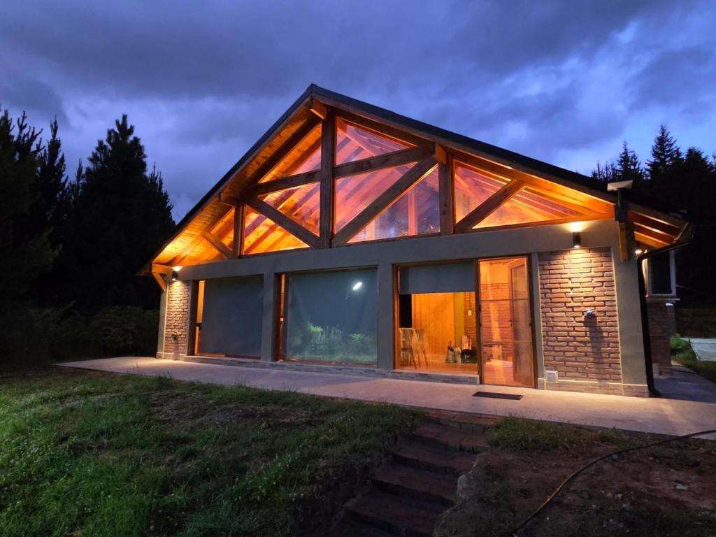 a house with large glass doors and windows at Cabaña Cholito in Lago Puelo