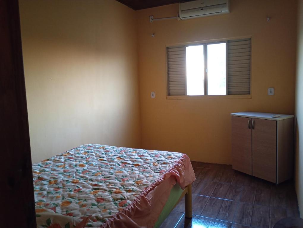 a bedroom with a bed and a window at Casa sobrado in Alegrete