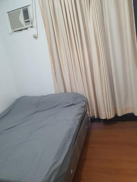 a bedroom with a bed and a window with a air conditioner at Palmetto condominium in Davao City