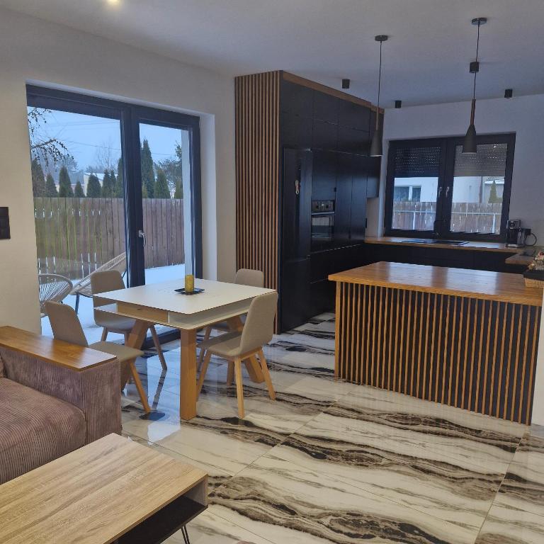 a living room with a table and a kitchen at Willa Rytel in Rytel
