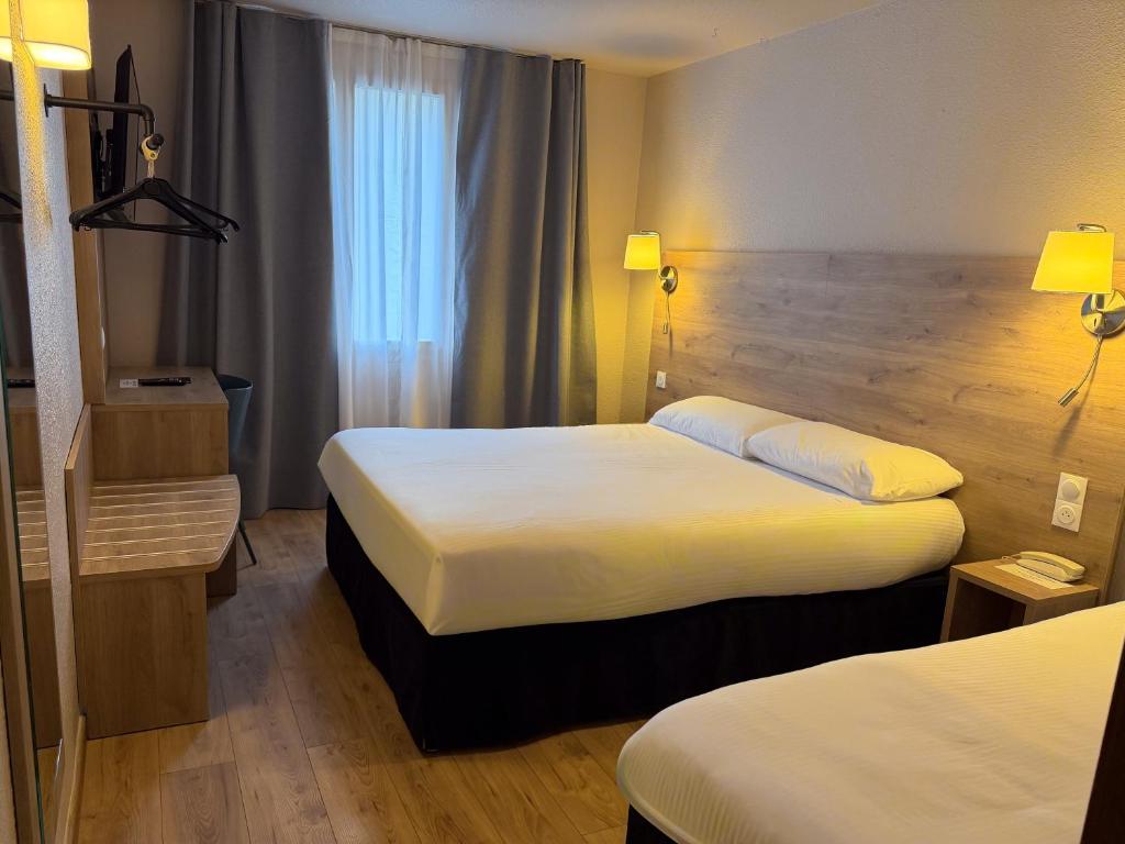 En eller flere senge i et værelse på Brit Hotel Confort Gien