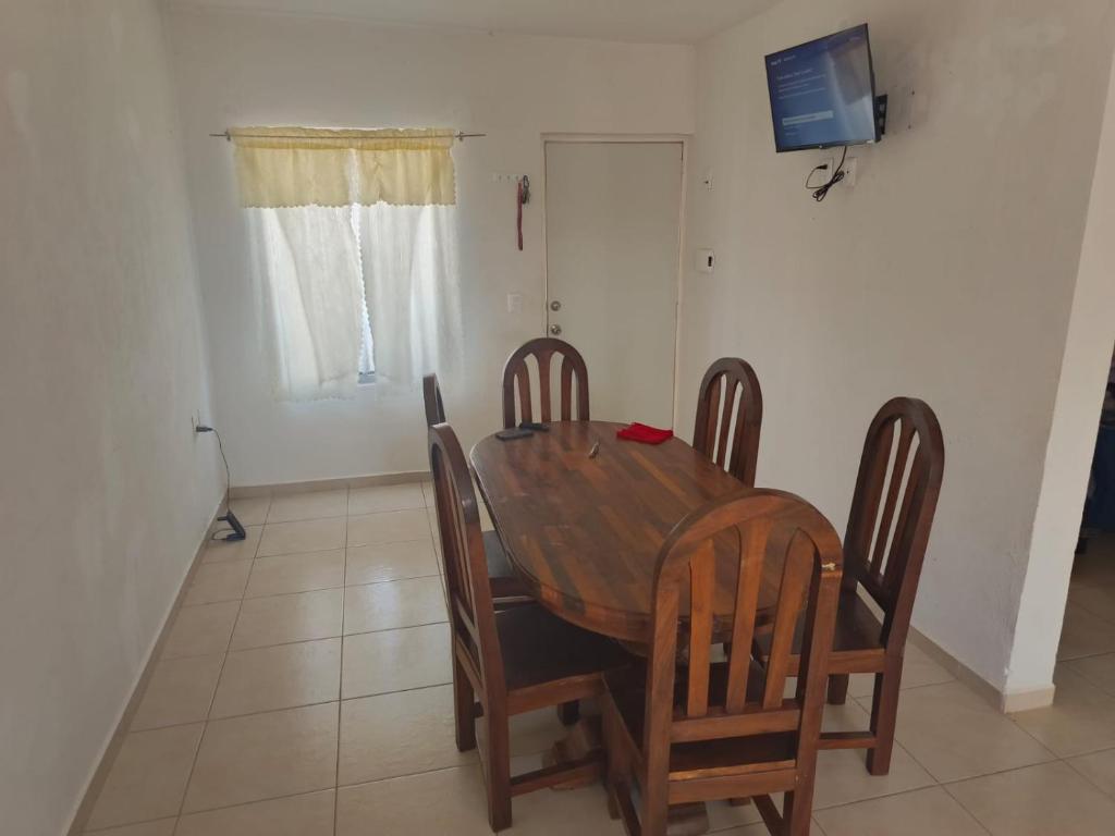 a dining room table with chairs and a television on the wall at Casa Roque in El Balcón