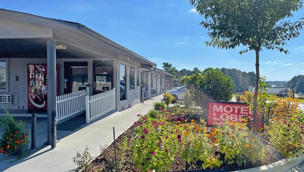 a motel with flowers in front of a building at Express Inn Thomson in Thomson
