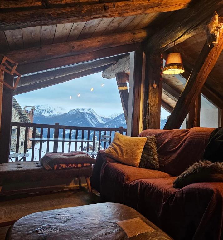 a living room with a couch and a mountain view at Chalet Lumière Alpine in La Salle