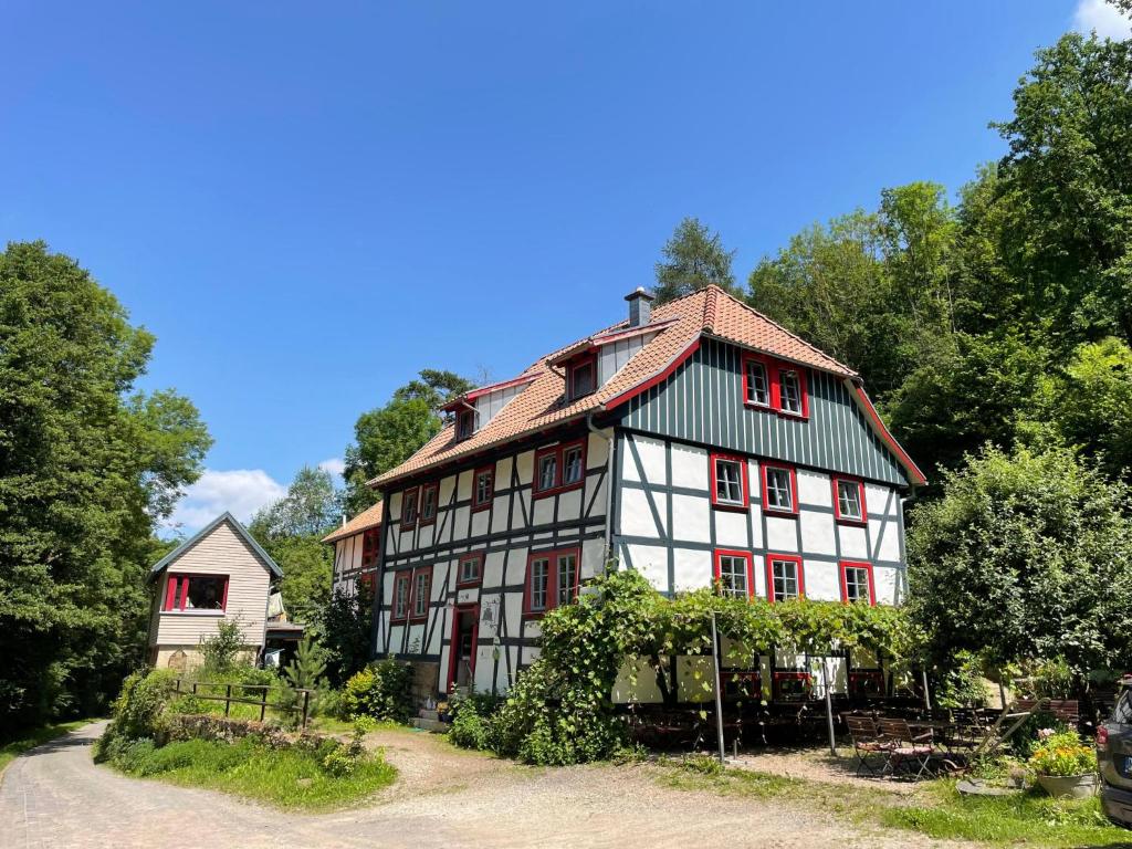 a large white and red building with trees in the background at Kaffeemühle Hamma II in Heringen