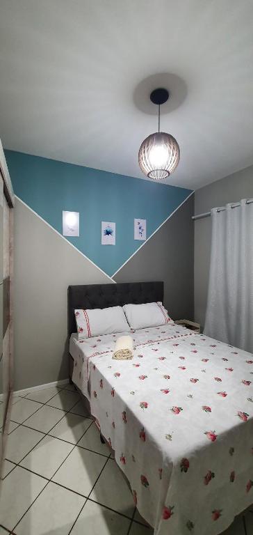 a bedroom with a large bed with a blue wall at Murilo House - Apart-hotel completo e privativo in São José