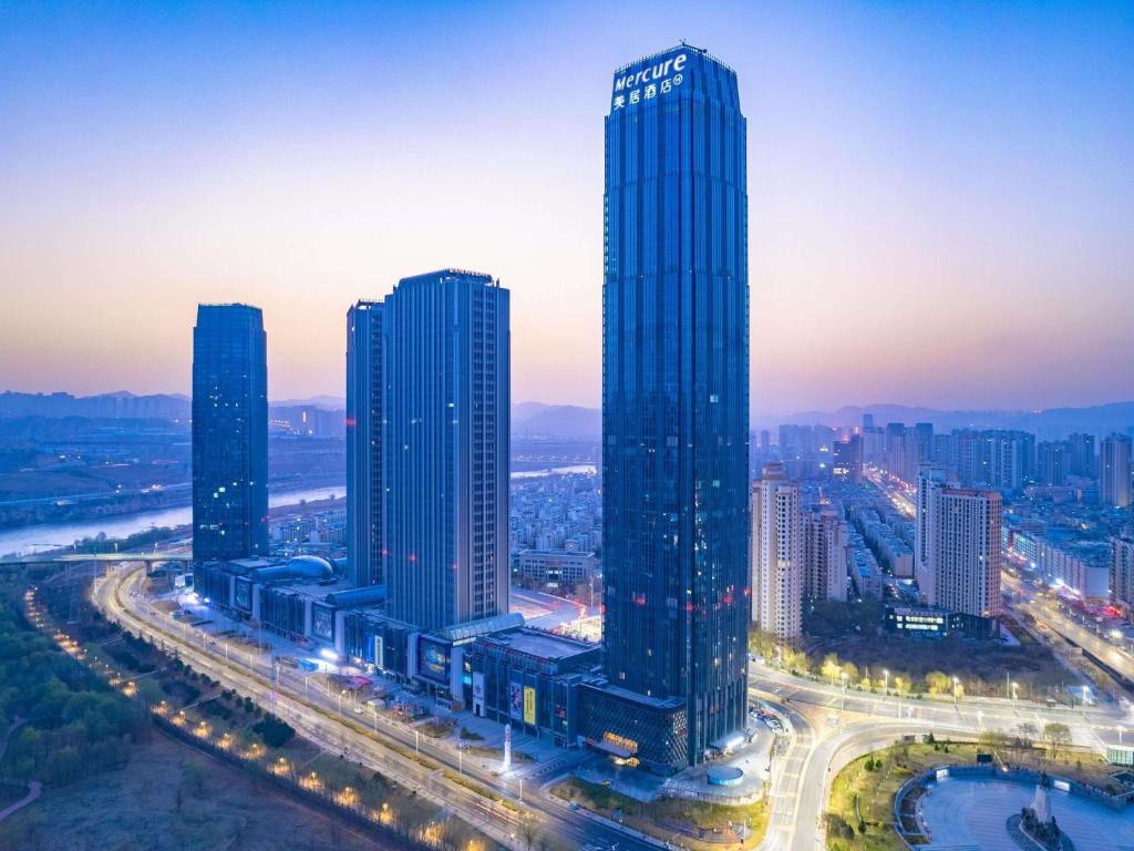 a group of tall buildings in a city at night at Mercure Lanzhou Downtown in Lanzhou