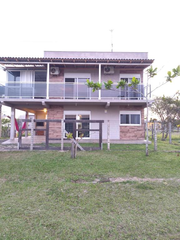 a house with a fence in front of it at Beach house - Praia Recreio Torres in Torres