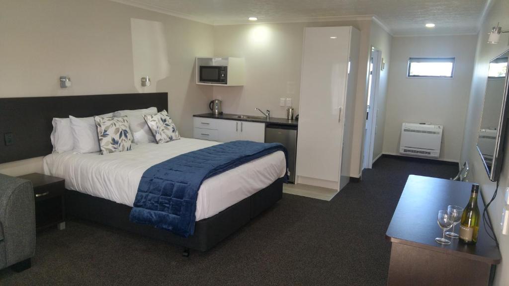 White Heron Motor Lodge في جيسبورن: غرفه فندقيه بسرير ومطبخ