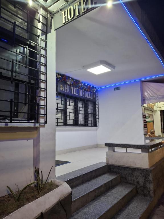 a hotel lobby with stairs and a sign on the wall at Hotel Medellin in Santa Marta