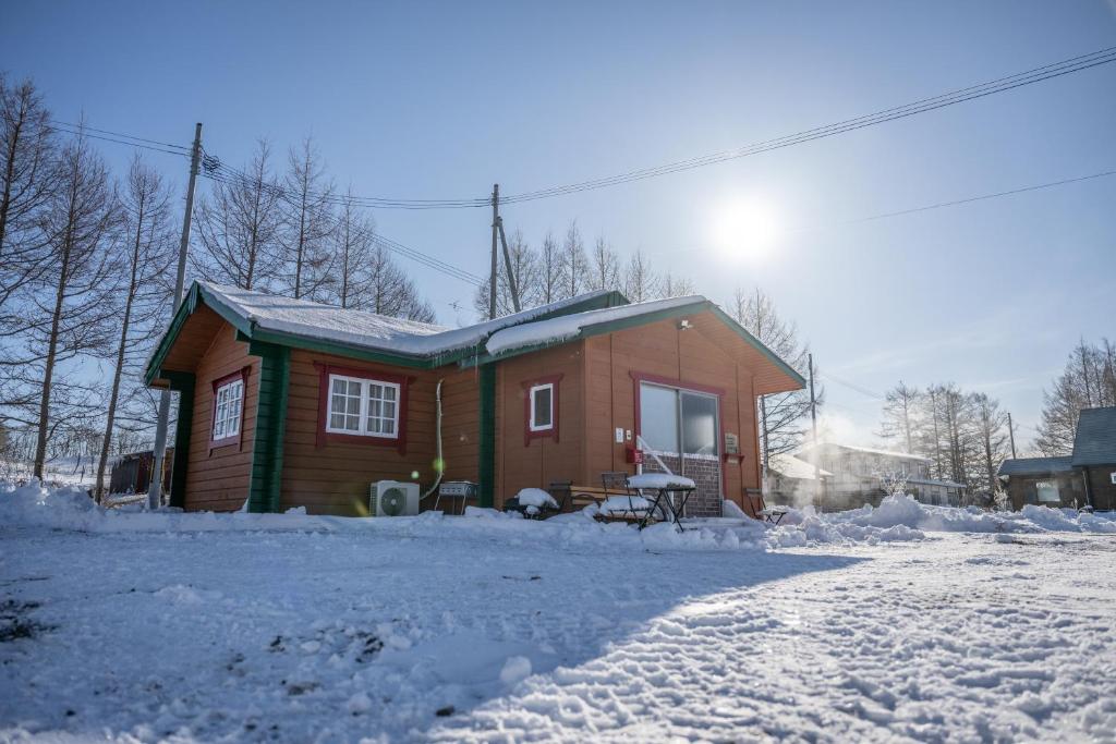 a small house with snow on the ground at コテージコッタロ in Gojikkoku