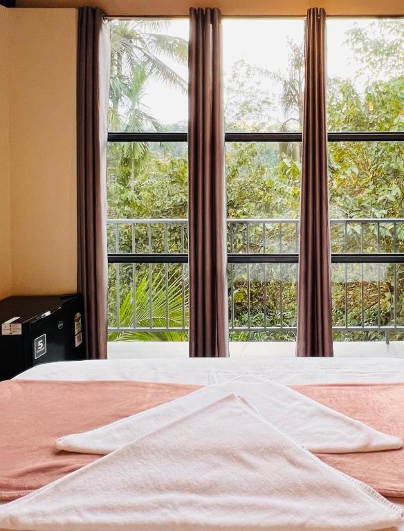 a bedroom with a large window and a bed at Hill View Heights Wayanad in Meppādi
