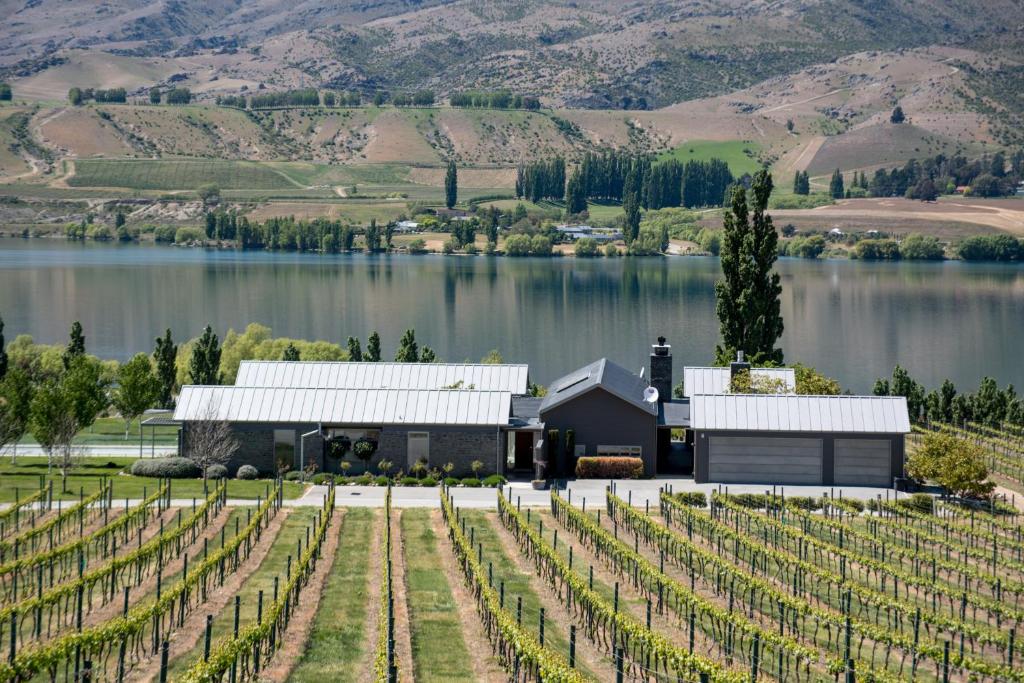 a vineyard with a barn and a lake at Mt Michael Lodge in Cromwell