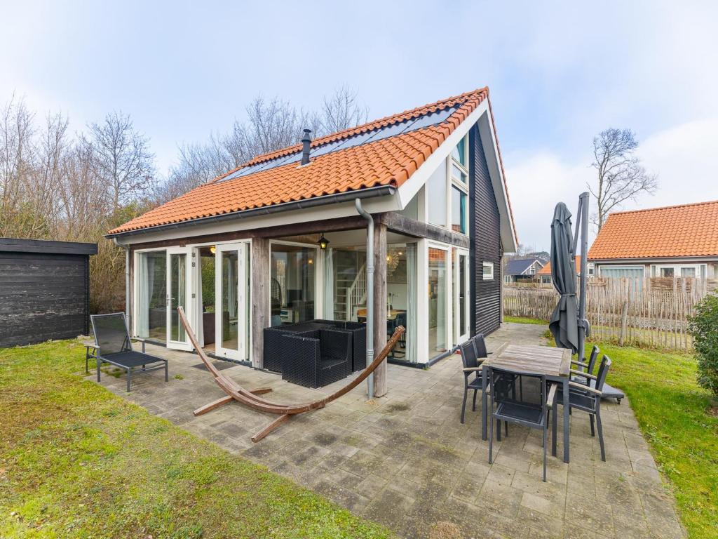 a small house with a roof on a patio at Coastal Family Escape with Enclosed Garden in Renesse