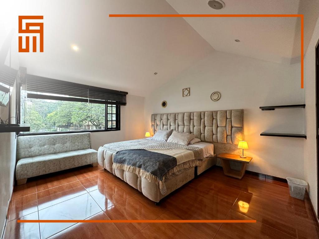 a bedroom with a large bed and a couch at Hotel Santa Ana Luxury Rentals - 111 in Bogotá