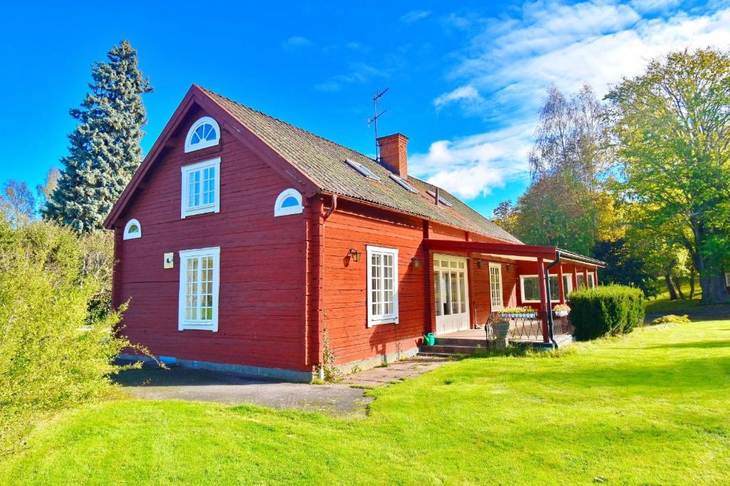 a small red house with a grassy yard at Ribbingshof Herrgård - Flygeln in Norra Vi
