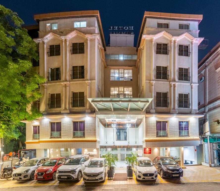 a hotel with cars parked in front of it at Hotel Summit in Ahmedabad