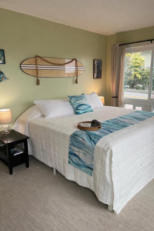 a bedroom with a bed with a surfboard on the wall at Kona Wave Rider - Island Sanctuary with Ocean Soul in Kailua-Kona