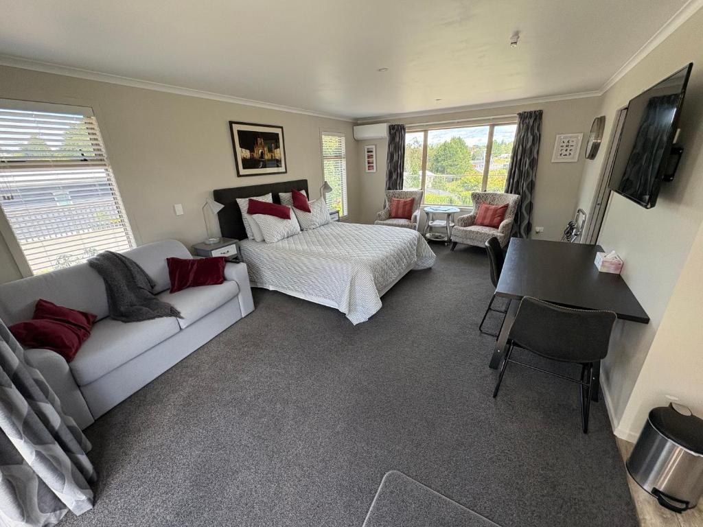 a living room with a bed and a couch at Cambridge Te Awa Rivertrail BnB in Cambridge