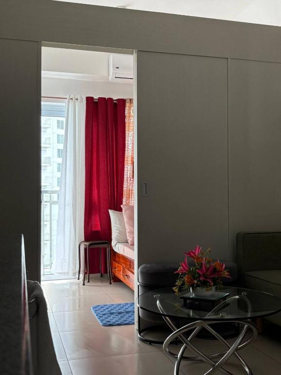 a living room with a table and a red curtain at RD Bliss Staycation - SMDC Condo Tower B in Kaybagal