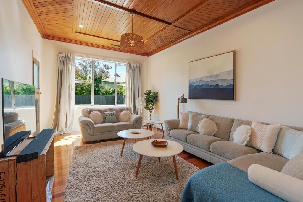 a living room with a couch and a table at Corokia Villa - Peaceful, Modern Villa in Richmond in Richmond