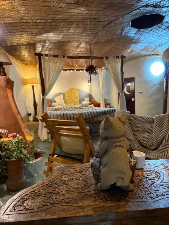 a teddy bear sitting on a table in a bedroom at The Cob House in Chauntrā