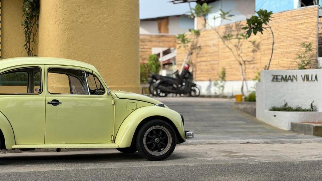 an old green car parked on the side of a street at Zeman Villa in Padang
