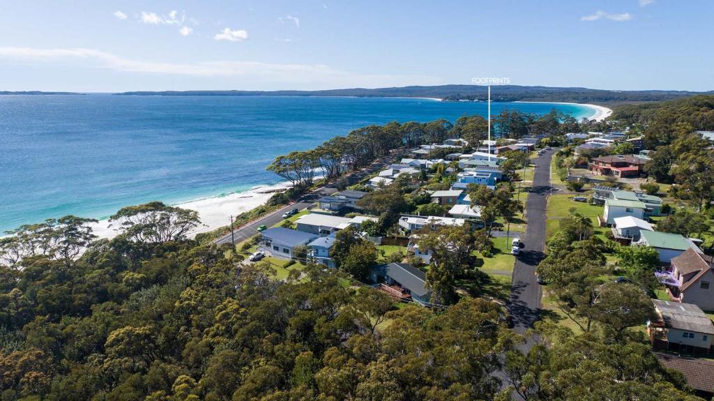 an aerial view of a beach with houses and the ocean at Footprints at Hyams Beach - 4BR home w. games room in Hyams Beach