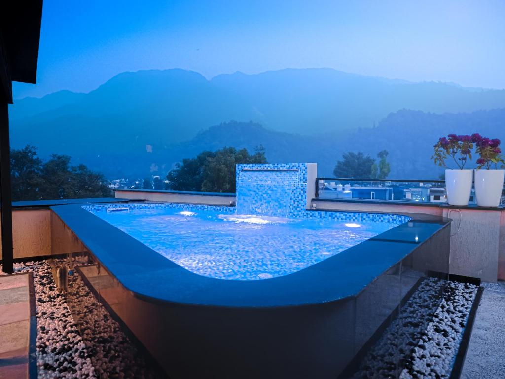 a swimming pool with a view of the mountains at Hotel Urban chant in Rishīkesh