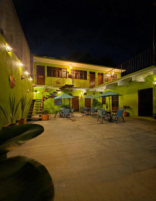 a building with a patio with tables and umbrellas at night at Habitaciones Casa Bule in Oaxaca City