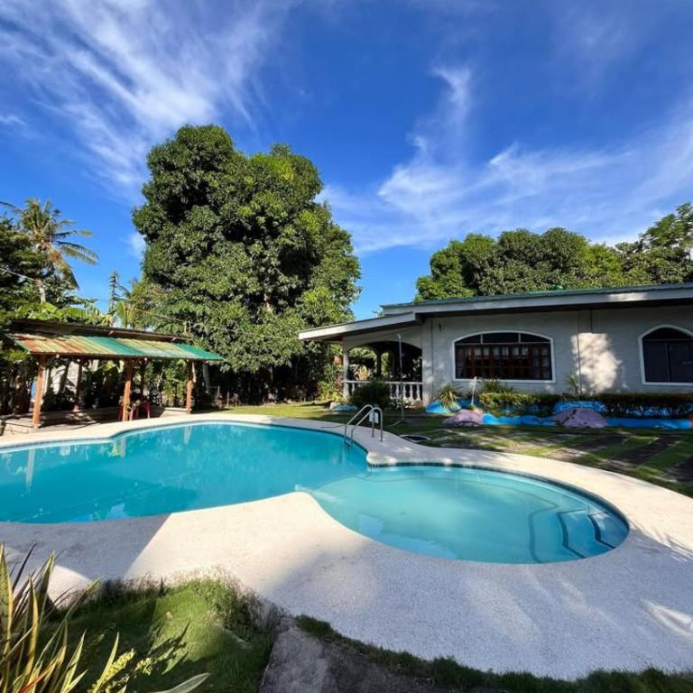 a swimming pool in front of a house at Alaba Vacation House w Pool and Beach Access in Mambajao