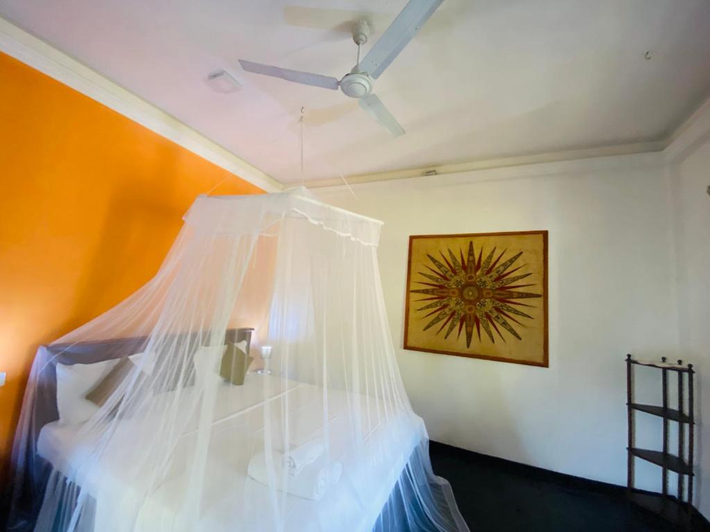 a bedroom with a bed with a mosquito net at Sri Villa in Dickwella