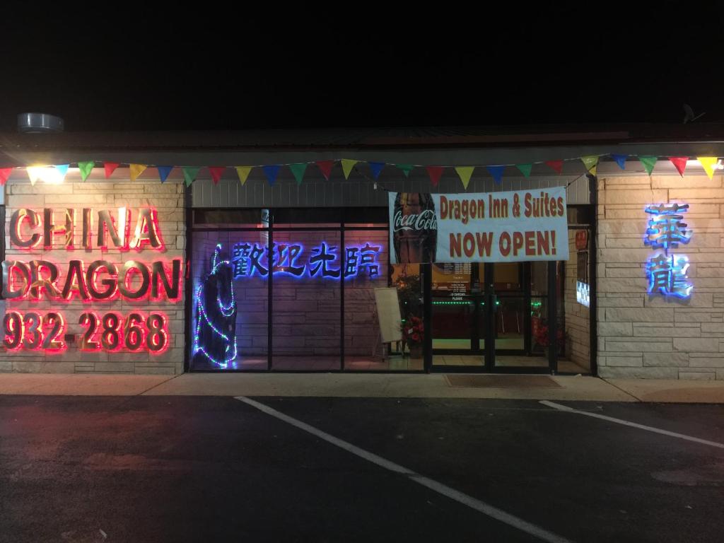 a store with signs on the front of it at night at Dragon INN & Suites in Fayette