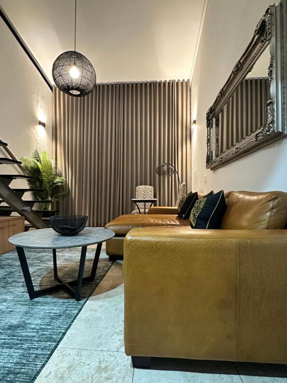 a living room with a couch and a table at Meerendahl Luxury Apartments at Tyger Lake in Cape Town