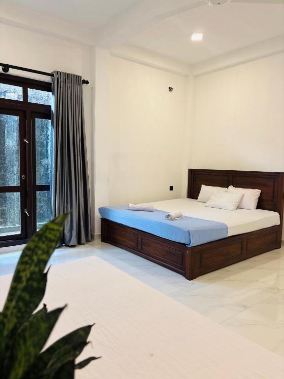 a bedroom with a bed and a large window at Blue Cinnamon Cove in Kosgoda