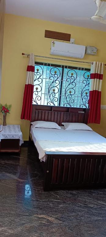 a bedroom with two beds and a window at Ronith's Cozy Stay in Gokarna