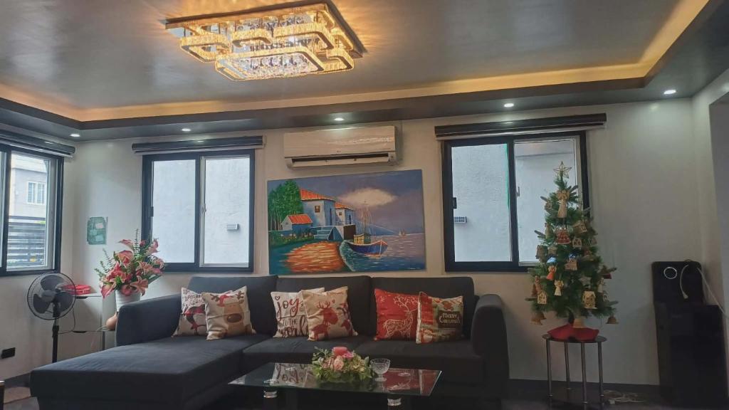 a living room with a couch and a christmas tree at Cai Residence - Stylish 2BR Staycation near EK & Tagaytay Gateway in Santa Rosa