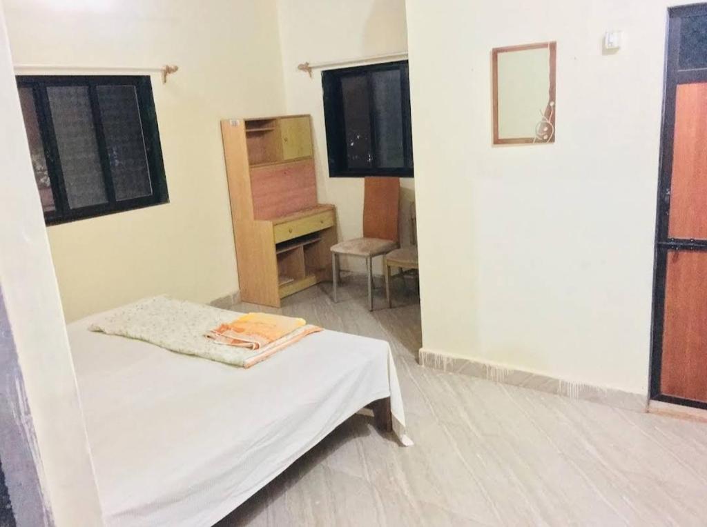 a room with a bed and a dresser and a tv at Homestay, Villa in Diveagar in Diveagar
