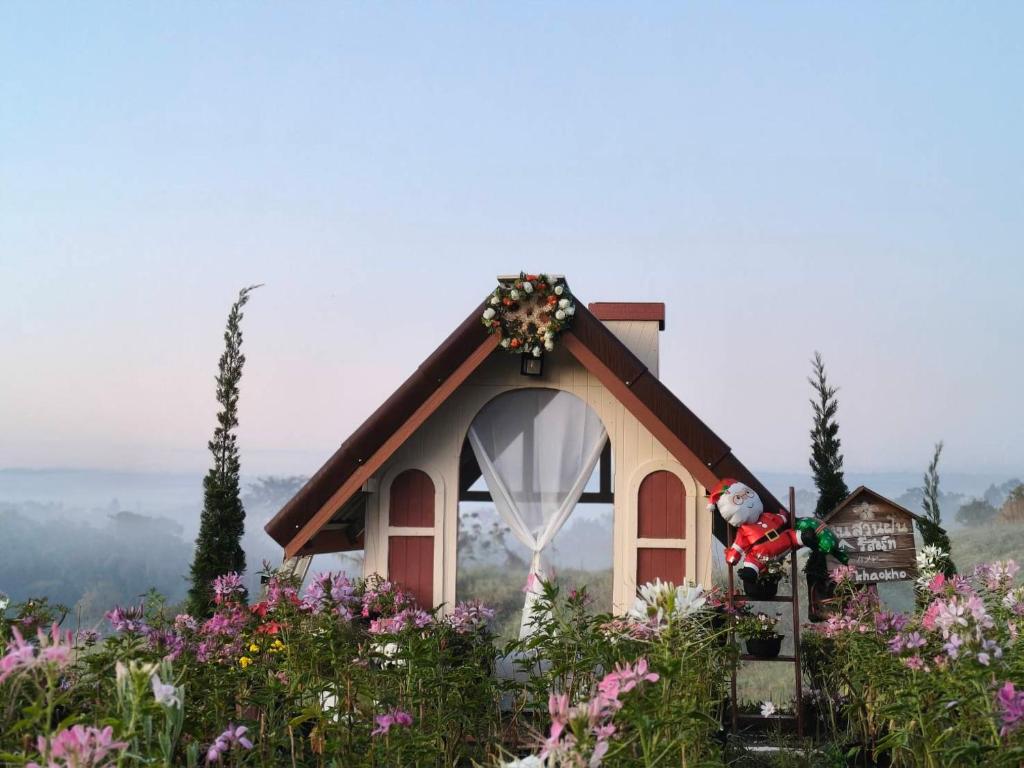 a santa claus in a small chapel in a field of flowers at Nai Suan Phan Resort - ในสวนฝัน รีสอร์ท in Ban Thung Samoe