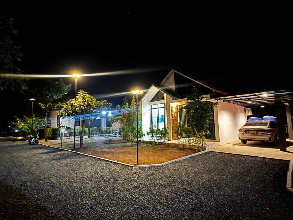 a house with a tennis court in front of it at night at กัสเกรซ โฮมสเตย์ in Pak Chong