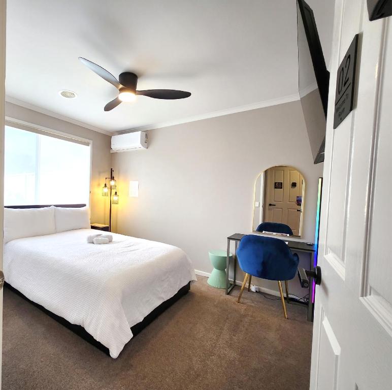 a bedroom with a bed and a desk with a blue chair at Private Room 2- Affordable Luxury in Craigieburn