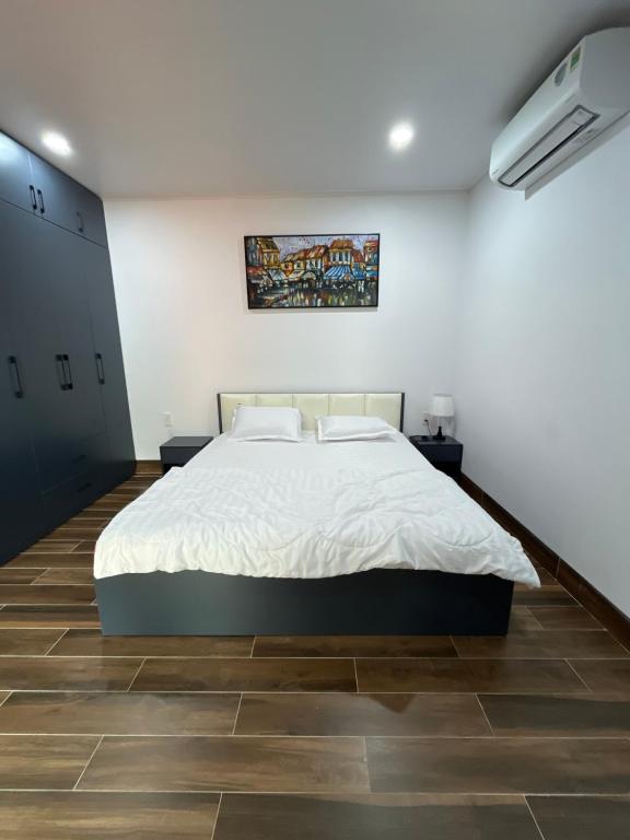 a bedroom with a large bed in a white wall at Melalueca tây ninh in Tây Ninh