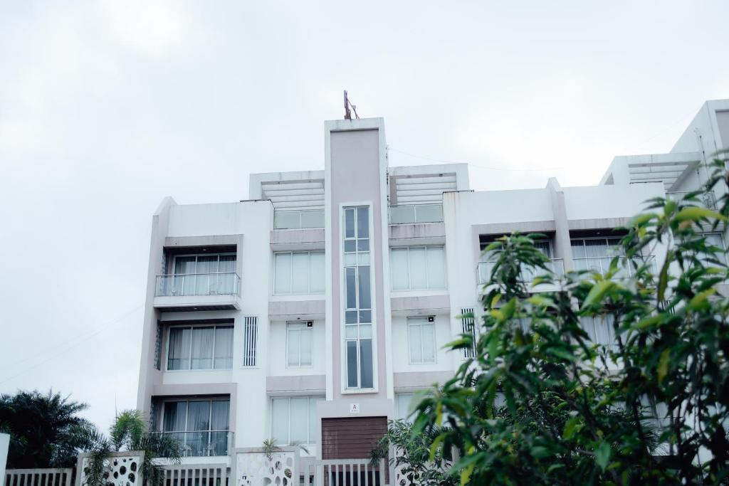 a white building with a cross on top of it at Capetown Shaadows in Igatpuri