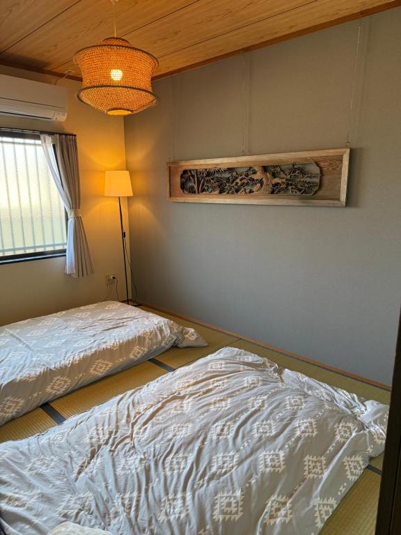 a bedroom with two beds and a lamp at A203 KASUMI-an 絢 in Kumamoto